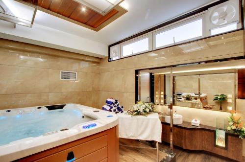 a bathroom with a tub and a large mirror at White Castle Boutique Apartment Hotel in Bangalore