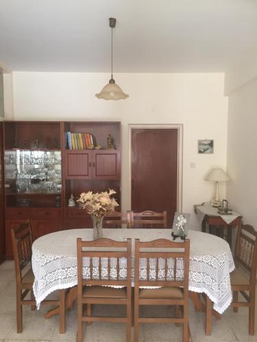a dining room table with chairs and a vase of flowers on it at Artemis House in Limassol