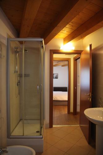 a bathroom with a shower and a sink and a bedroom at Trauner Rooms Collection in Trieste