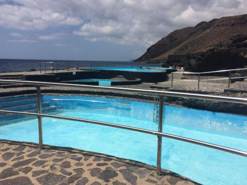 een rij zwembaden naast de oceaan bij Salitre in La Caleta