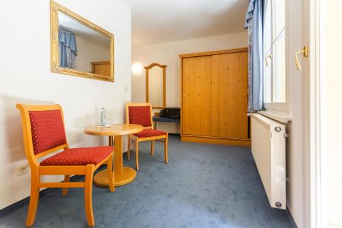 a room with two chairs and a table and a mirror at Hotel Erbprinzenpalais in Wernigerode