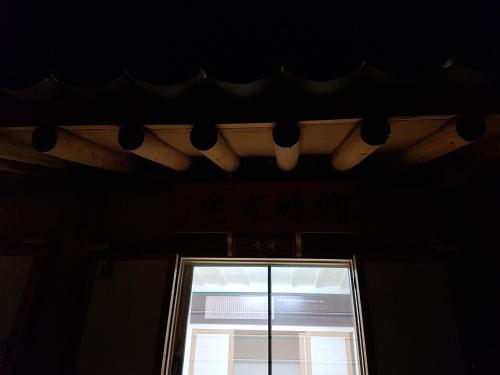 a window in a dark room with lights on the ceiling at Jukheon Traditional House in Andong