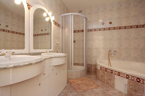 La salle de bains est pourvue de 2 lavabos, d'une baignoire et d'une douche. dans l'établissement Szabó Ház, à Hévíz
