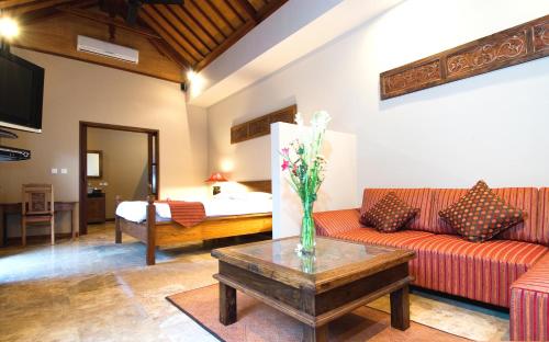 a living room with a couch and a table at Ajanta Villa in Sanur