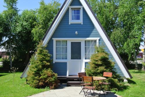 a blue house with a table and chairs in front of it at Camping Marco Polo in Łeba