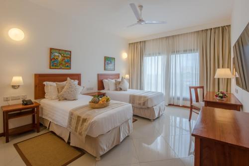 a hotel room with two beds and a table at Sea Cliff Court Hotel & Luxury Apartments in Dar es Salaam