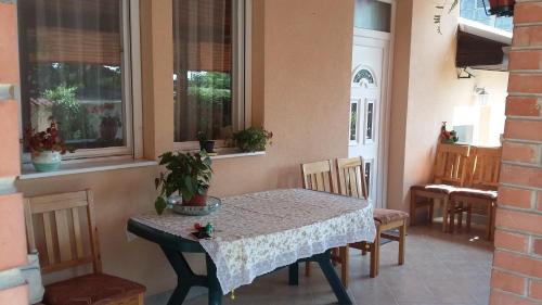 Pál utcai Apartman Miskolc في ميشكولتْس: طاولة وكراسي في غرفة مع طاولة ونوافذ