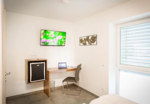a room with a desk and a tv on a wall at Hotel Restaurant Sailer in Seewalchen
