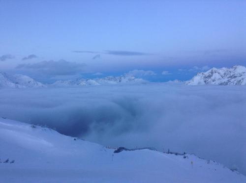 a group of snow capped mountains above a layer of clouds at Haus Heiss in Prutz