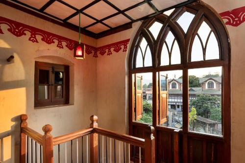 a room with a staircase and a large window at Chateau Garli in Garli