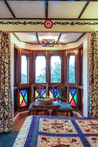 a room with a table and chairs and windows at Chateau Garli in Garli
