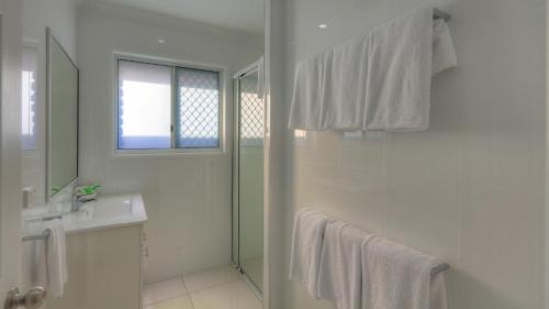 a white bathroom with a shower and a sink at Heritage Lodge Motel in Charters Towers