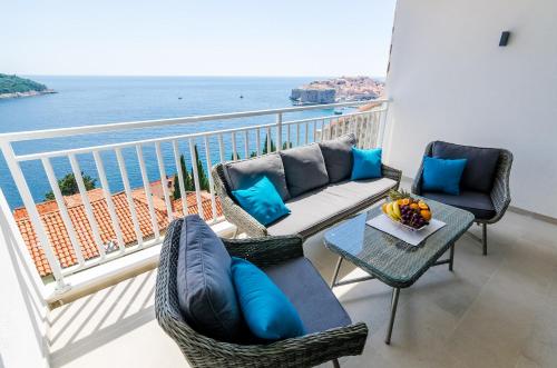 uma varanda com cadeiras, um sofá e uma mesa em Apartments Lazarin em Dubrovnik