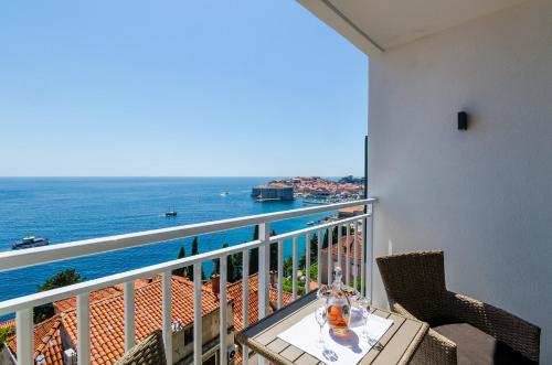 a balcony with a table with a view of the ocean at Apartments Lazarin in Dubrovnik