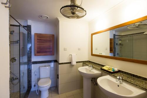 a bathroom with a sink and a toilet and a mirror at Sea Cliff Court Hotel & Luxury Apartments in Dar es Salaam