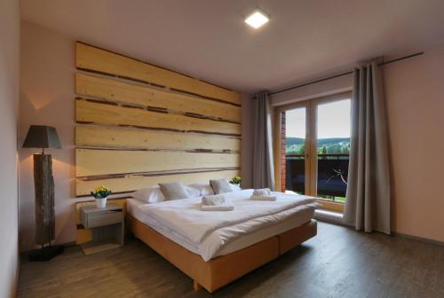 a bedroom with a large bed and a large window at Hotel Obzor in Pec pod Sněžkou