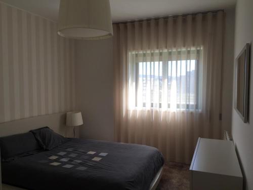 a bedroom with a bed and a window at Casa na Praia in Póvoa de Varzim