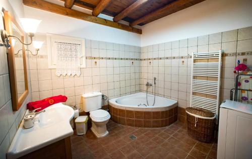 a bathroom with a tub and a toilet and a sink at Jasmine House in Tsilivi
