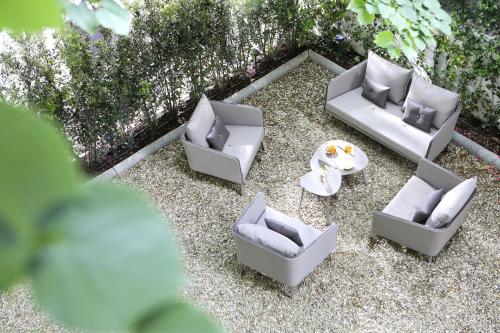 four white chairs and a table on the ground at Messori Suites in Florence