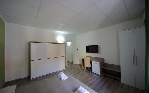 a room with a bed and a desk and a tv at Nidi di Feo in Lecce