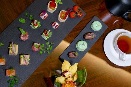 a table with a plate of sushi and a cup of coffee at BURJ ON BAY Hotel in Jounieh
