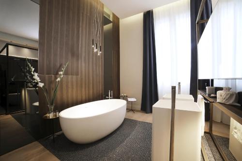 a bathroom with a large white tub and a sink at Messori Suites in Florence