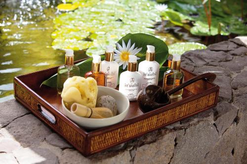 a wooden tray with bottles of soap and a bowl of food at Grand Hotel Del Mare Resort & Spa in Bordighera