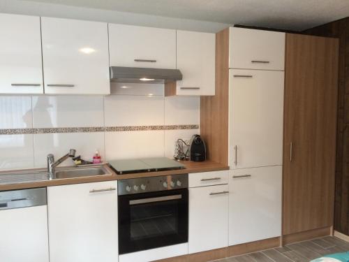 a kitchen with white cabinets and a sink at Casa Riposo in Flumserberg