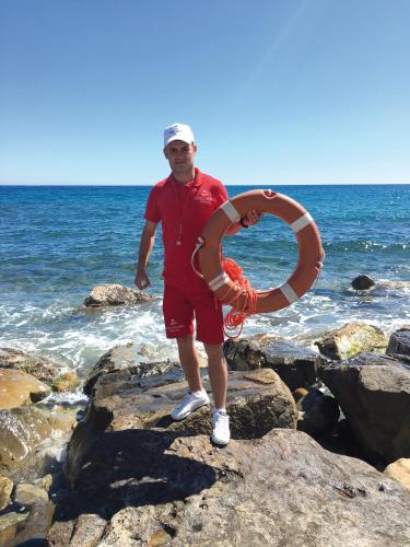 a man standing on the rocks with a life preserver at Grand Hotel Del Mare Resort & Spa in Bordighera