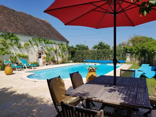 - une table en bois avec un parasol à côté de la piscine dans l'établissement Tourterelle, à proximité de Auxerre et Chablis, à Hauterive