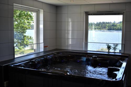 a bath tub with a view of the water at Håveruds hotell och konferens in Håverud