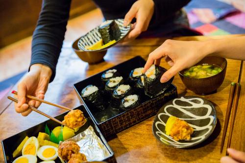 a group of people eating sushi on a table at Araiya Tokyo -Private Townhouse- in Tokyo
