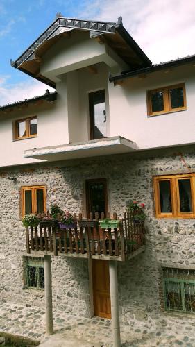 a house with a balcony in front of it at Aste Guesthouse in Tropojë