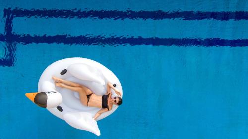 a woman laying in an inflatable whale in the water at BURJ ON BAY Hotel in Jounieh