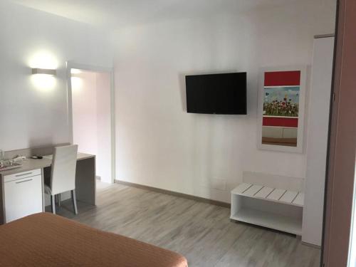 a white room with a desk and a television on a wall at Nidi di Feo in Lecce