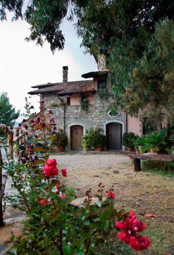 an old stone house with red flowers in front of it at Carretiello in Roccadaspide
