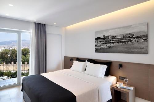 a hotel room with a large bed and a large window at Poseidon Athens Hotel in Athens