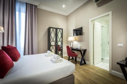 a hotel room with a bed and a desk and a chair at Hotel Emma Small Luxury Hotel in Florence