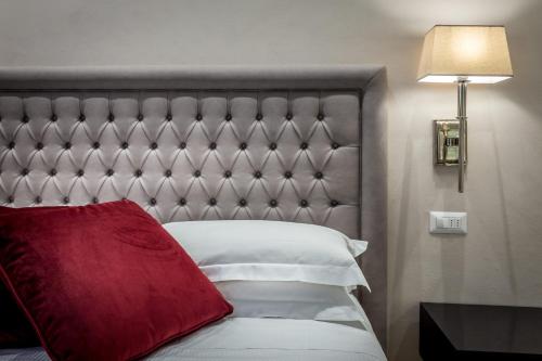 a bed with a red pillow on top of it at Hotel Emma Small Luxury Hotel in Florence