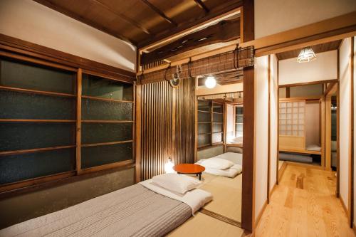a bedroom with two beds and a table in it at Araiya Tokyo -Private Townhouse- in Tokyo