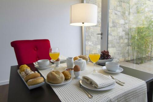 a table with breakfast foods and glasses of orange juice at Hotel Vila D'Óbidos in Óbidos