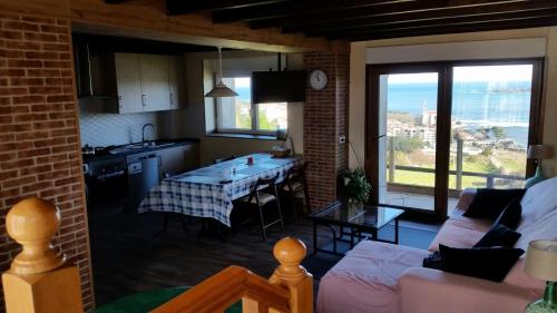 a kitchen and a living room with a table at Casa Buena Vista in Mundaka