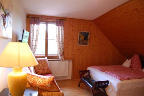 a bedroom with a bed and a window and a lamp at Gasthof Martinihof in Latschach ober dem Faakersee