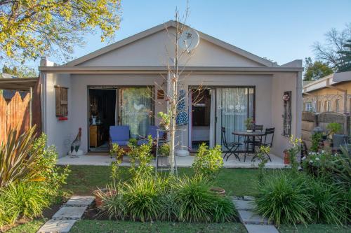 a small white house with a patio at Mirabel Guesthouse in Parys