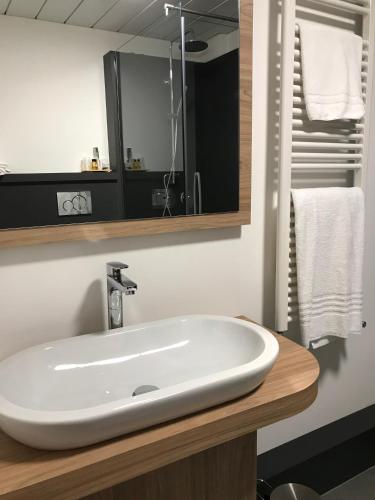 a bathroom with a white sink and a mirror at Hotel Gardenia in Romano Canavese