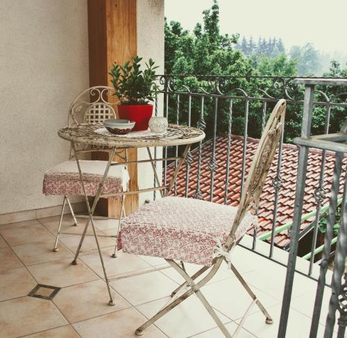 a table and two chairs on a balcony with a table at Prenočišča Angelin hram, Tiny Apartments in Markovec