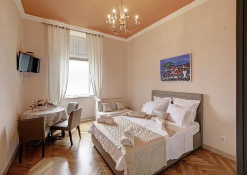 a bedroom with two beds and a table and chairs at The Beachfront Dubrovnik Old Town in Dubrovnik