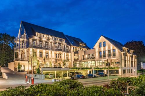 a large building with cars parked in front of it at AKZENT Hotel Villa Saxer in Goslar