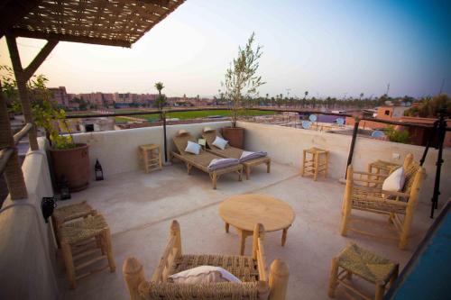 a patio with a table and chairs on a balcony at Riad Shambala in Marrakesh