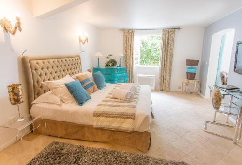 a bedroom with a large bed and a window at Hotel Le Verger Maelvi in Grimaud